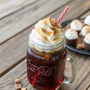 Campfire Cola Dirty Soda in a mason jar with whipped cream and marshmallow